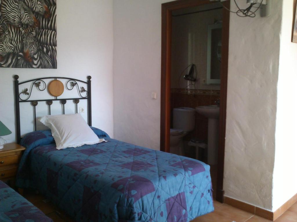a bedroom with a bed and a bathroom with a mirror at Xanadu Rural in Chiclana de la Frontera
