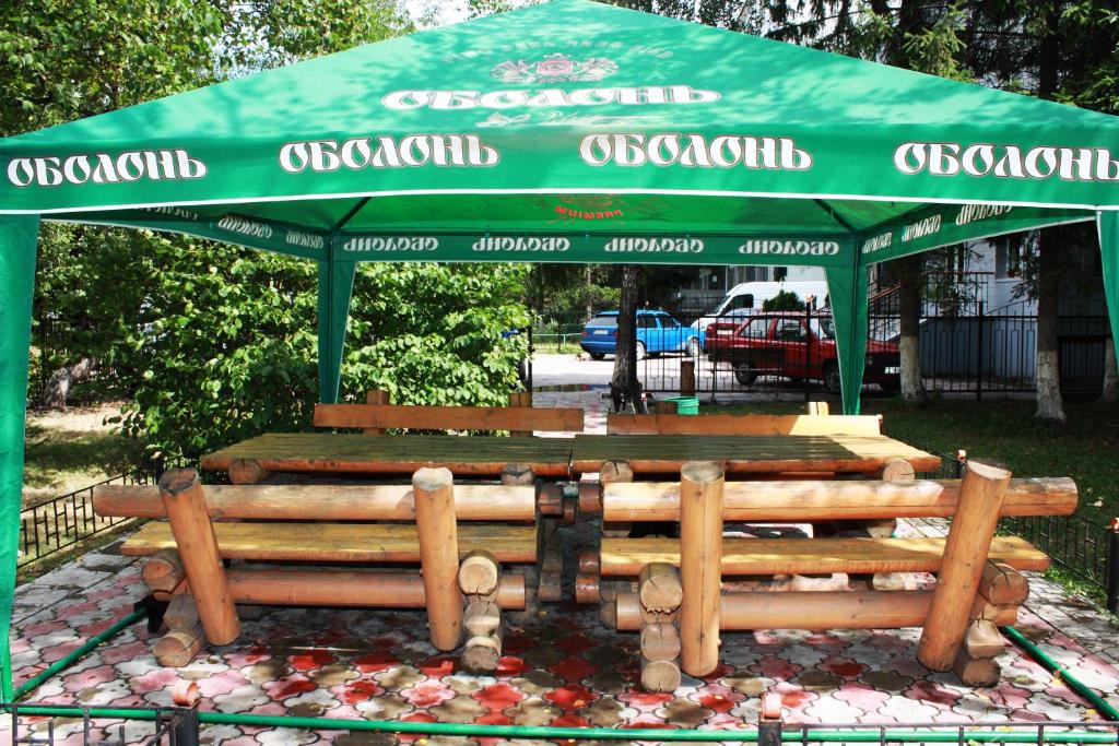 a group of wooden benches under a green canopy at Vydubychi in Kyiv