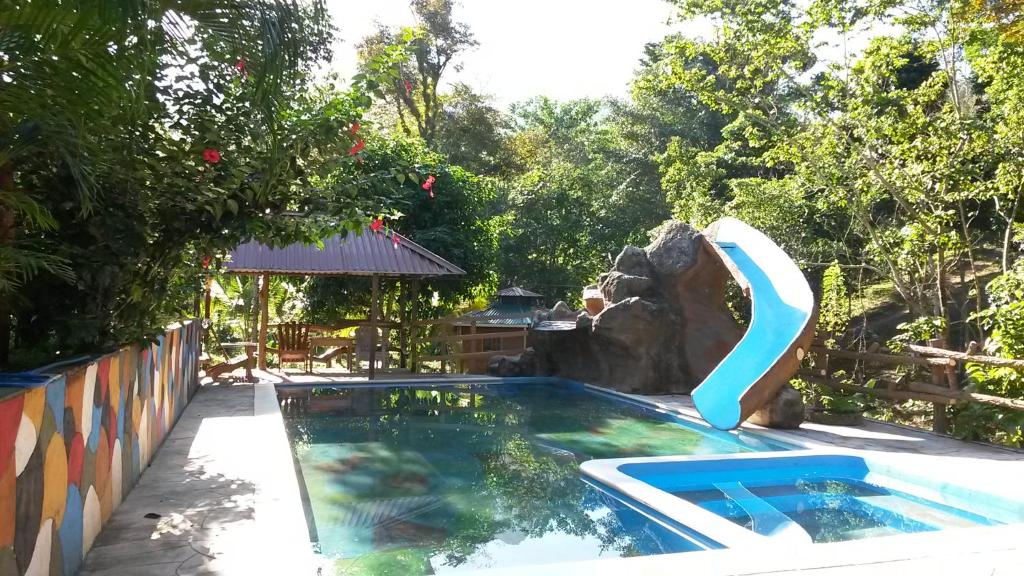 a swimming pool with a slide in a backyard at Hilamito Lodge in Tela