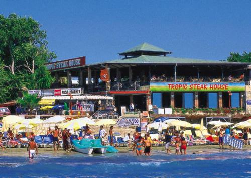 a group of people on a beach with umbrellas at Tropic Hotel in Side