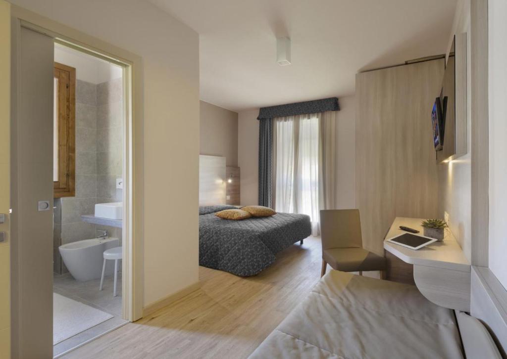 a hotel room with a bed and a bathroom at Locanda Benetti in Costabissara