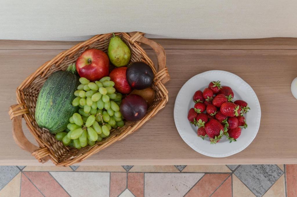 a basket of fruit on a table with a plate of fruit at Astir Of Naxos in Naxos Chora