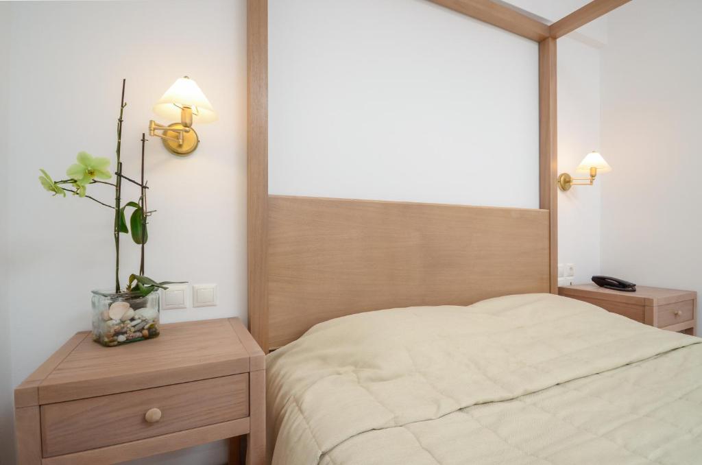 a bedroom with a bed and two tables and a window at Astir Of Naxos in Naxos Chora