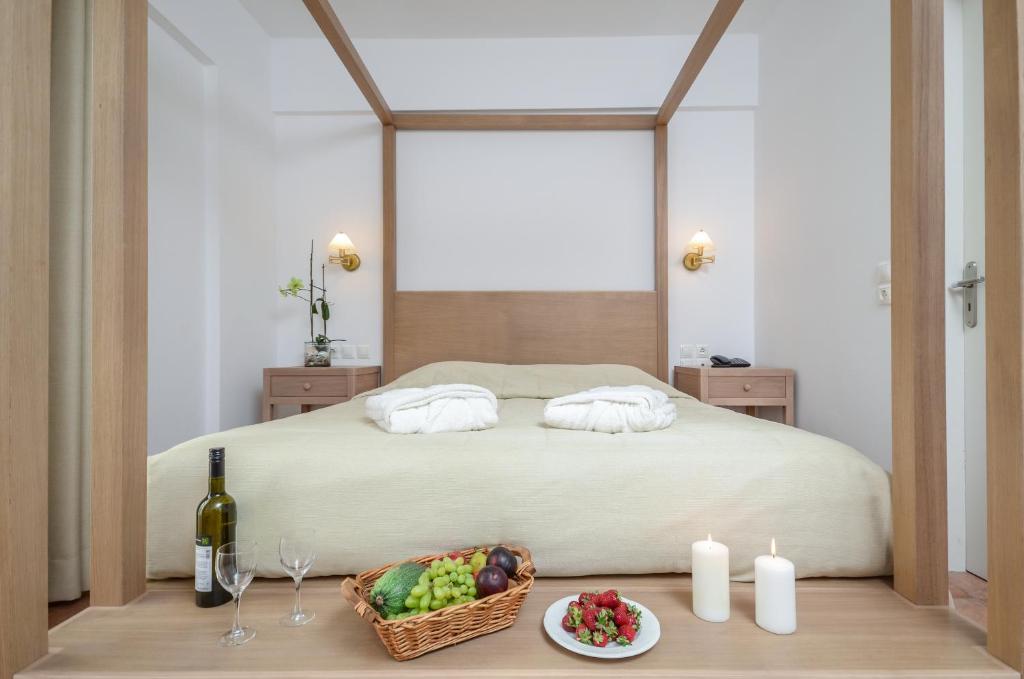 a bedroom with a bed with a basket of fruit on a table at Astir Of Naxos in Naxos Chora