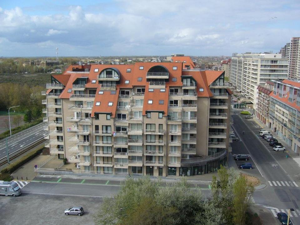 um grande edifício de apartamentos com telhado laranja em Res Apollo Nieuwpoort em Nieuwpoort