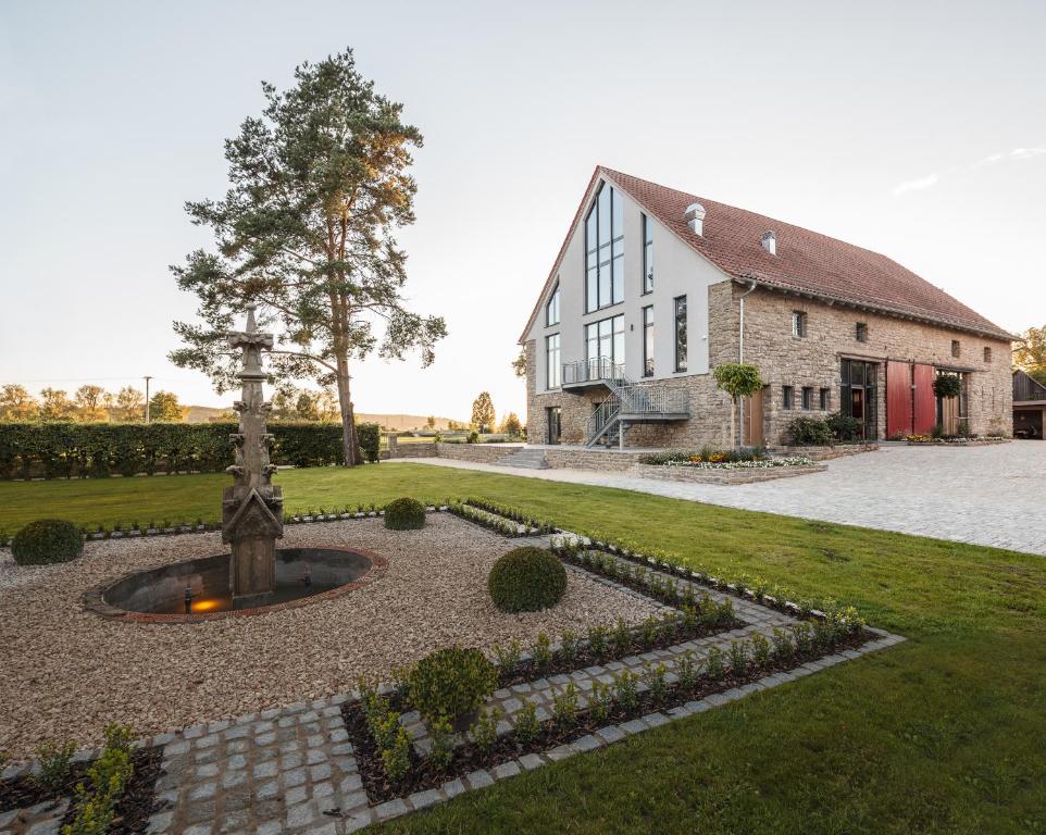 einen Garten mit einem Brunnen vor einem Gebäude in der Unterkunft Hotel Dorfmühle in Lehrberg