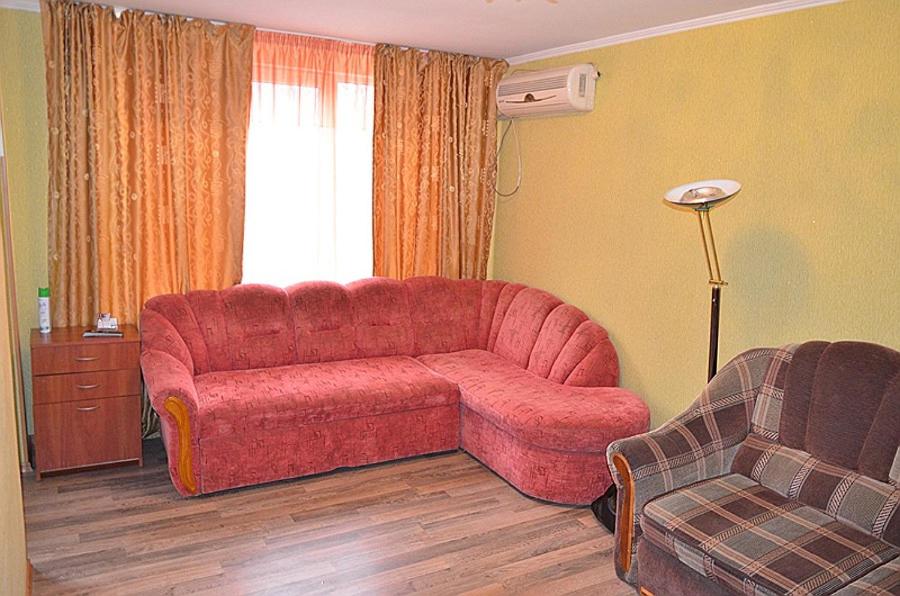 ヘルソンにあるZheleznodorozhnaya Street Apartments Centerのリビングルーム(赤いソファ、椅子付)