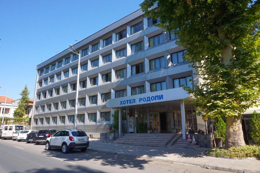 ハスコヴォにあるRodopi Hotelの建物の前に車が駐車されている