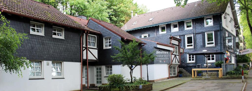 eine Gruppe von Gebäuden in einer Straße mit Bäumen in der Unterkunft Hotel Nüller Hof in Wuppertal