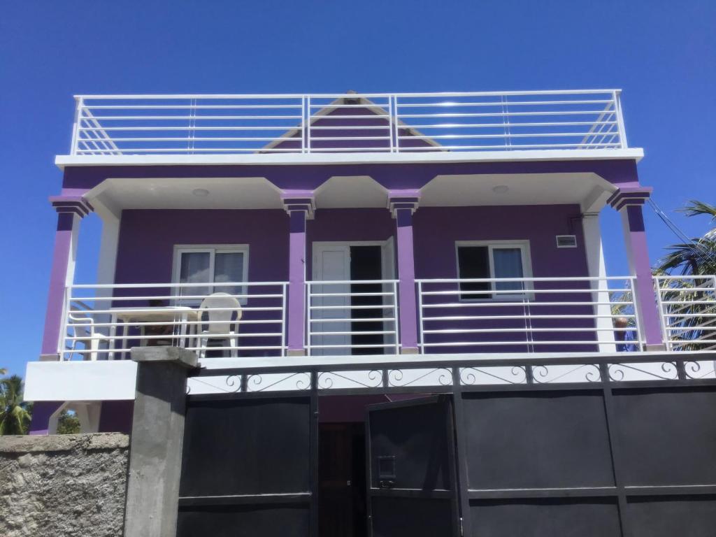 ein lila Haus mit Balkon darüber in der Unterkunft Villa Violette in Ambatoloaka