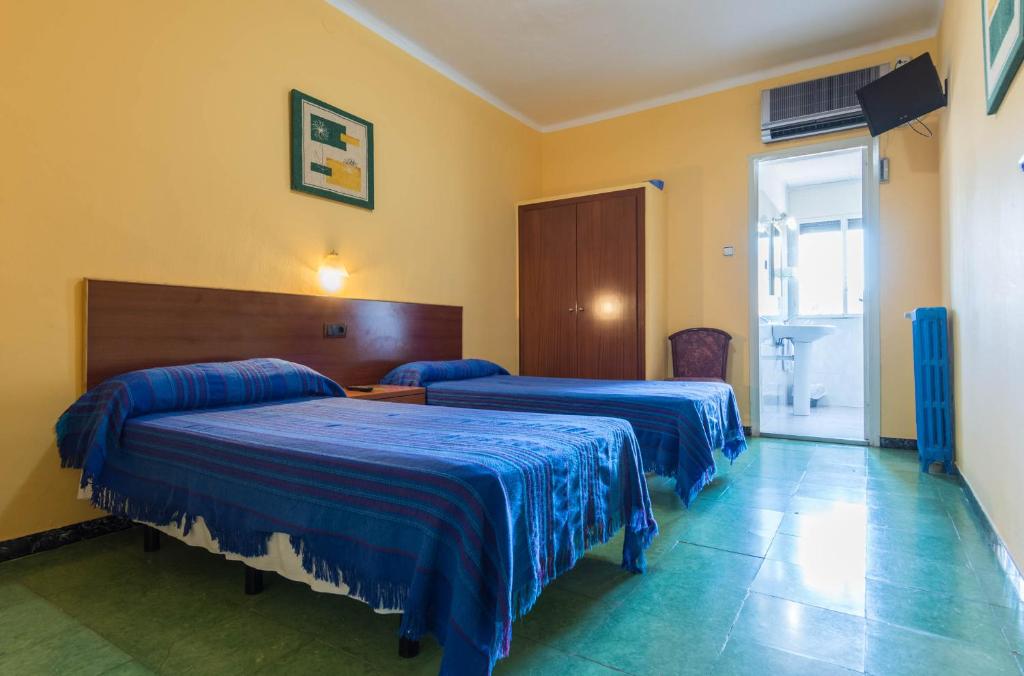 una habitación de hotel con 2 camas en una habitación en Hostal Urgell, en Balaguer