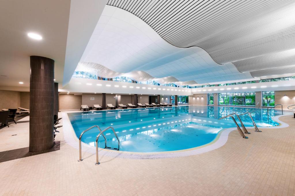 una gran piscina en el vestíbulo del hotel con una gran piscina en Parklane Resort and SPA, en San Petersburgo