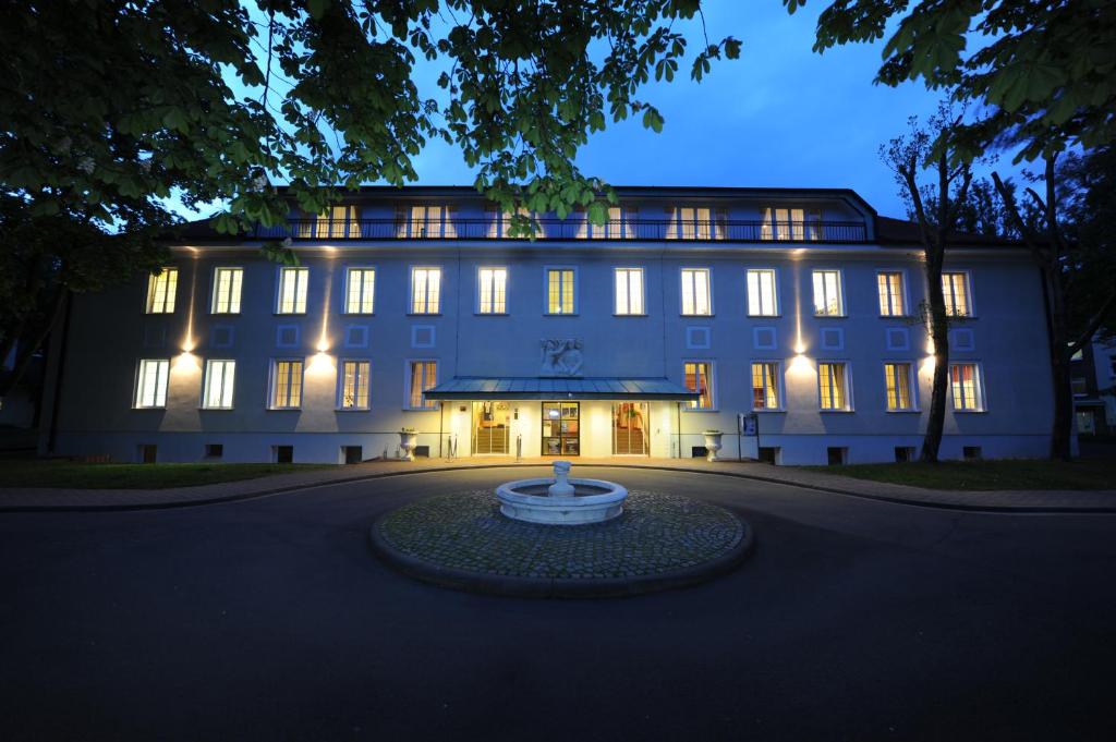 a large building with a fountain in front of it at Hotel Der Lindenhof in Gotha