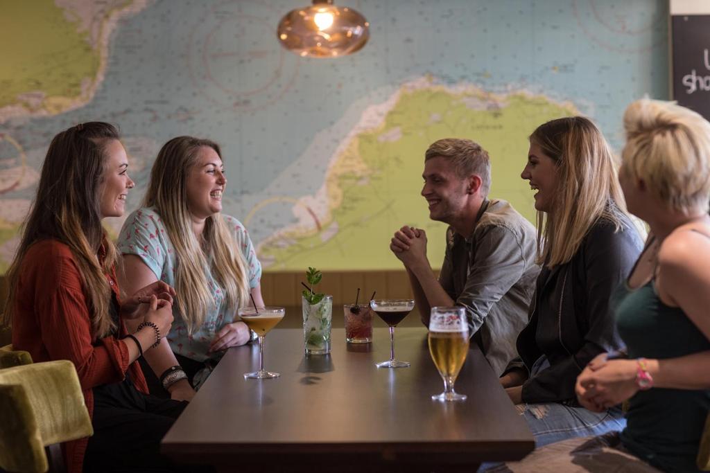 a group of people sitting around a table with wine glasses at Nether Abbey Hotel in North Berwick