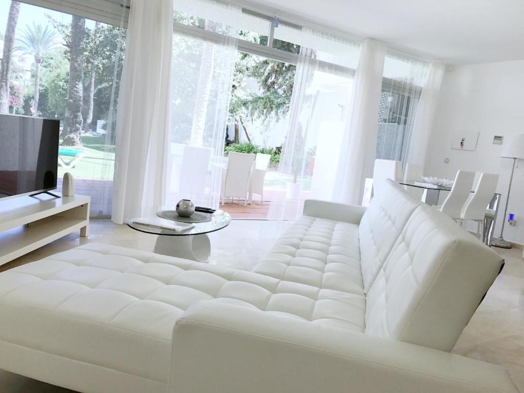 マルベーリャにあるVivaldi Boutique Suites Jardines del Marの白いリビングルーム(白いソファ、テレビ付)