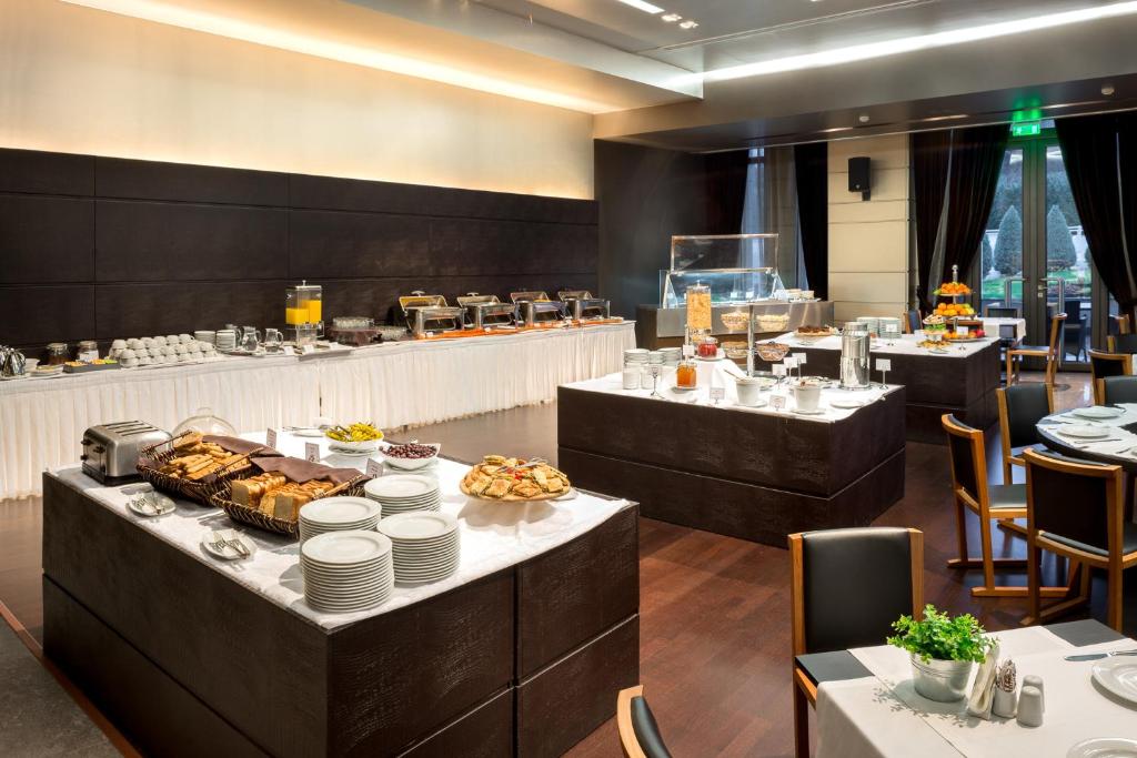 un restaurante con una línea de buffet con comida en las mesas en Esperos Palace Luxury & Spa Hotel, en Kastoria