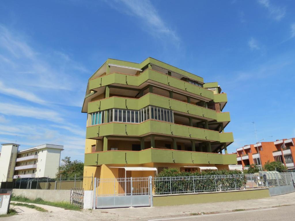 un edificio verde con una recinzione di fronte di Mansarda Bilocale Vista Mare a Lido delle Nazioni