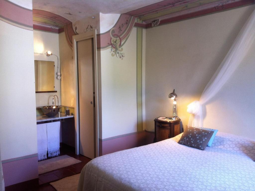 a bedroom with a bed and a bathroom with a sink at Dimora San Sebastiano in Neive