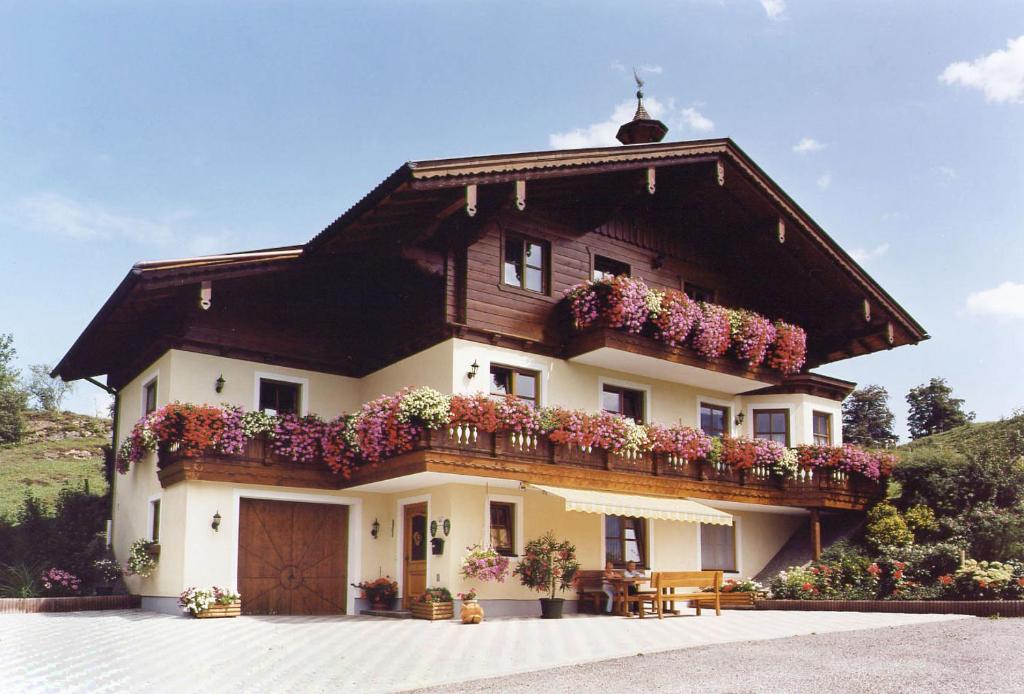 uma casa com uma varanda com flores em Haus Goldeggblick em Goldegg