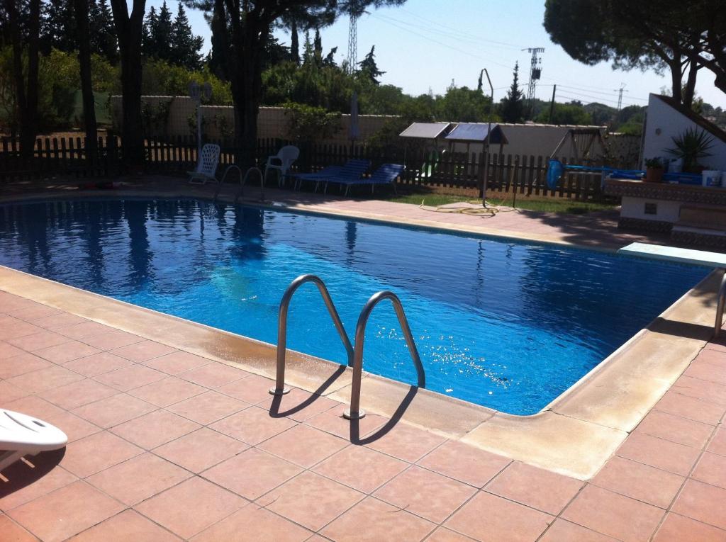 a swimming pool with blue water in a yard at Xanadu Rural in Chiclana de la Frontera