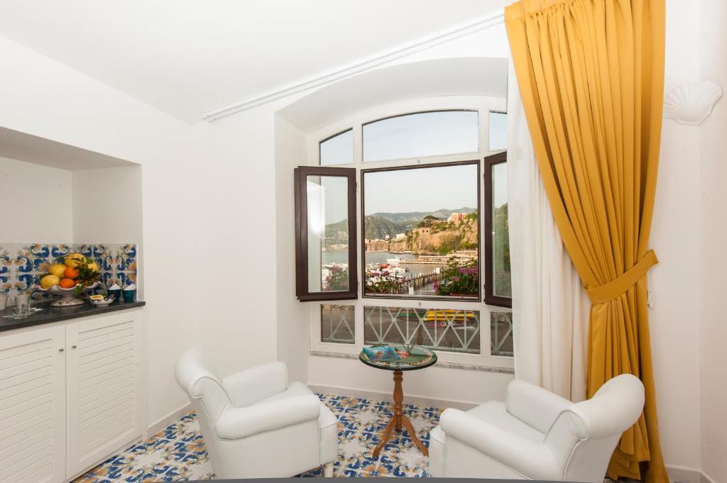 a living room with two chairs and a window at Surriento Suites in Sorrento