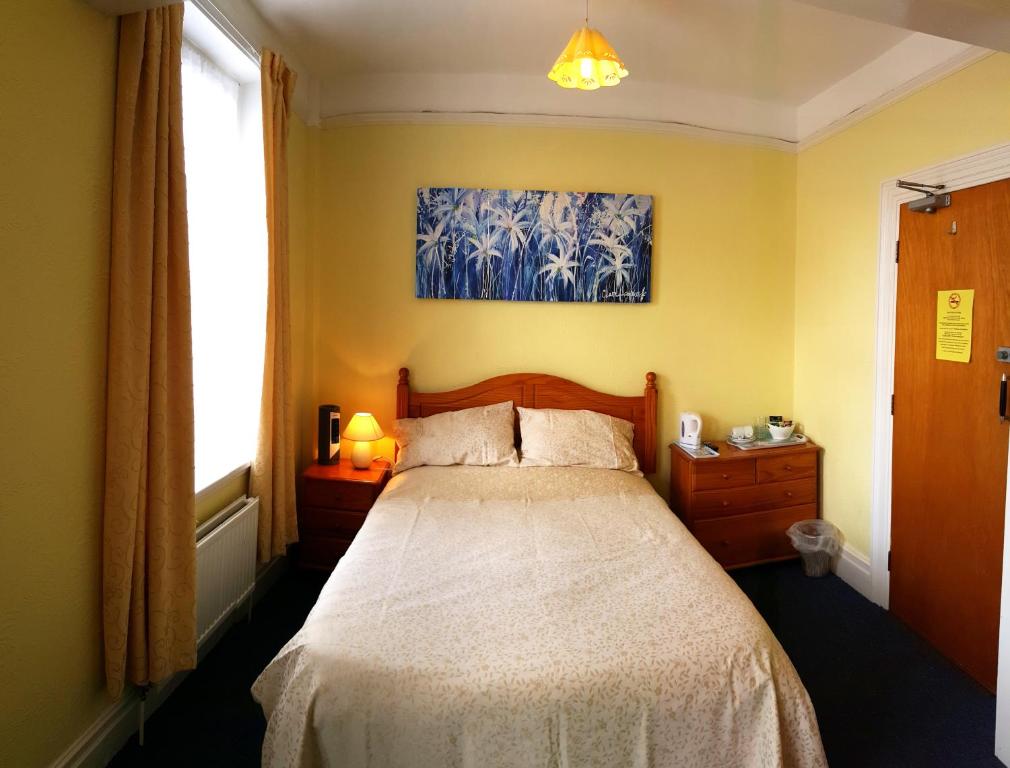 a bedroom with a bed and a painting on the wall at The Ratcliffe Guest House in Paignton