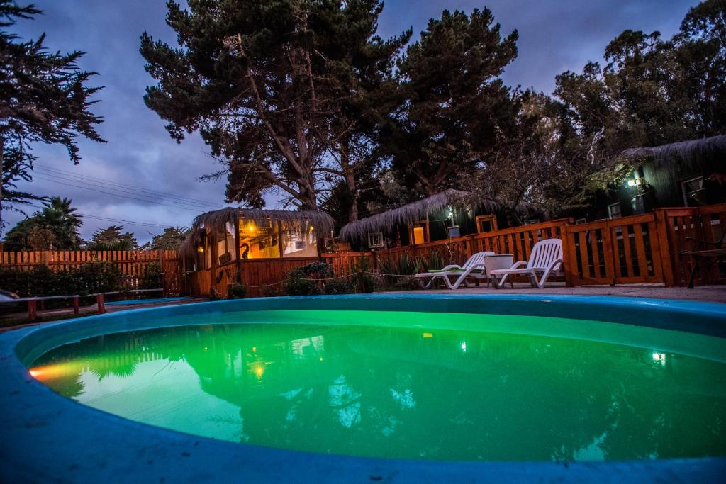 - une piscine dans une cour la nuit dans l'établissement "PINARES DEL MAR" Pequeñas cabañas ECO rusticas sello "S", à Isla Negra