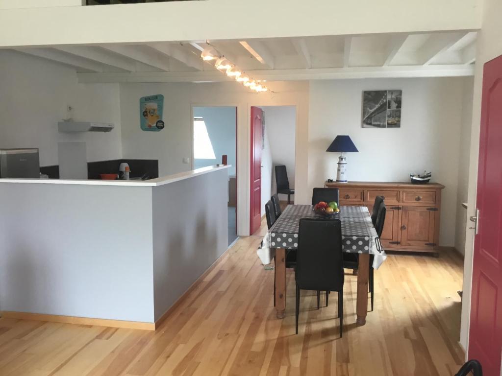 a dining room and kitchen with a table and chairs at location appartement in Wissant