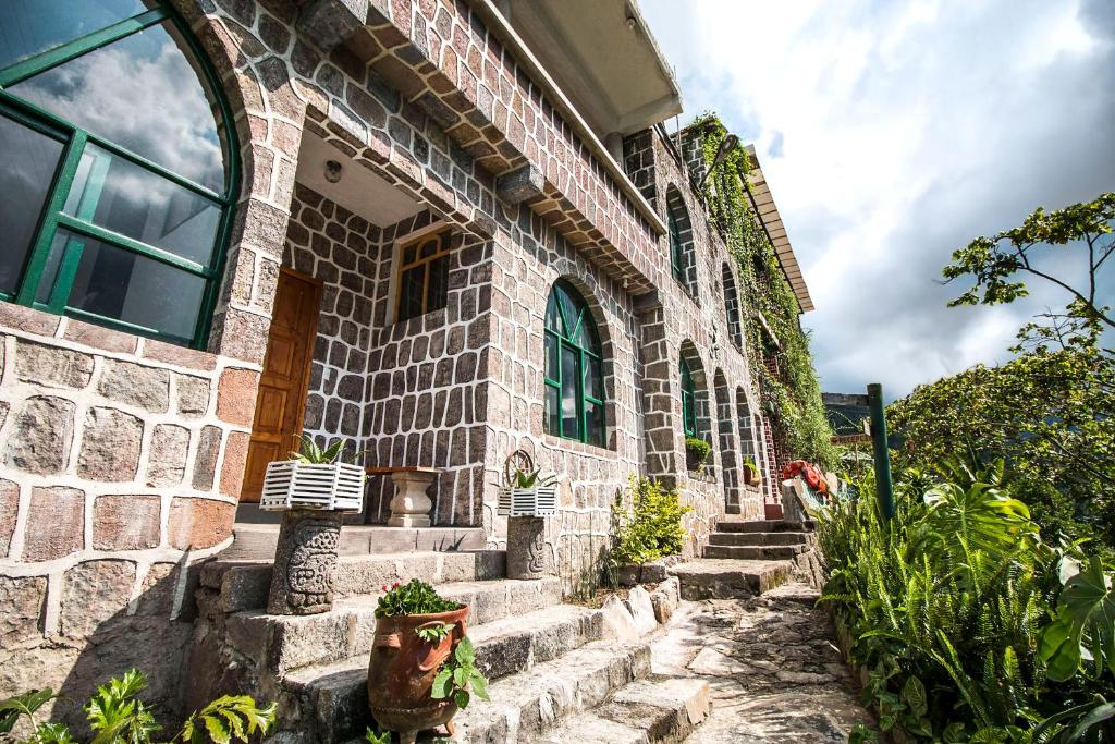 um edifício de pedra com escadas em frente em Eco Hotel Uxlabil Atitlan em San Juan La Laguna