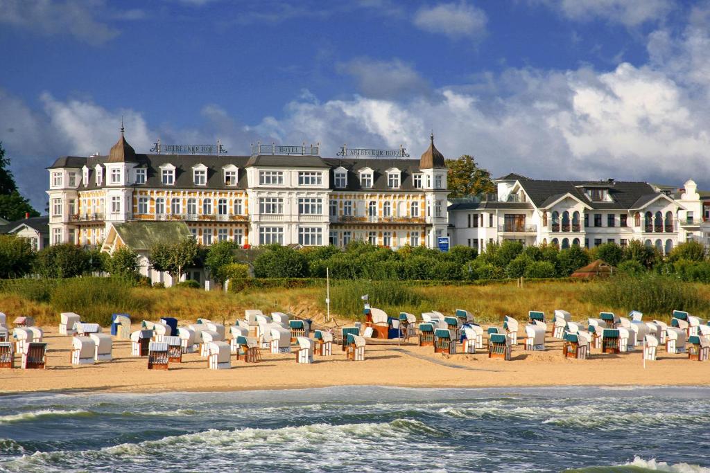a large building on the beach with chairs and the ocean at SEETELHOTEL Ahlbecker Hof in Ahlbeck