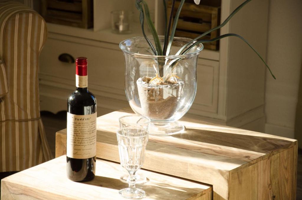een fles wijn en twee glazen op een tafel bij Hus Achterliek in Steinhude