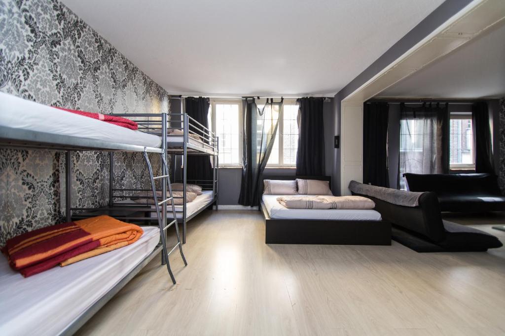 a dorm room with bunk beds and a couch at Altstadt Düsseldorf 1 in Düsseldorf