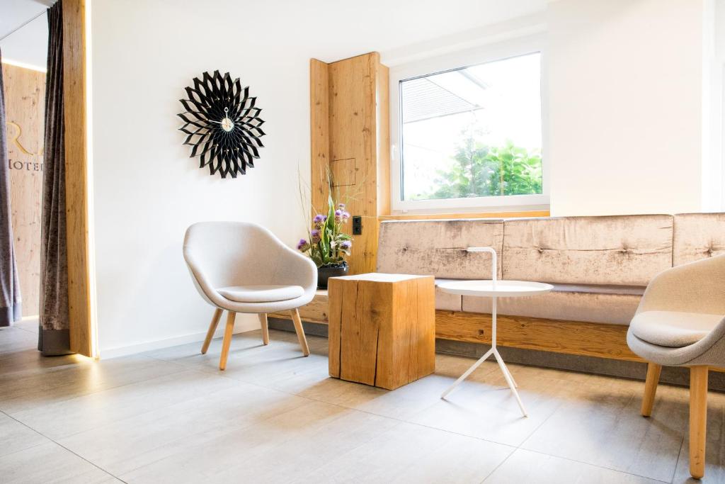 een kamer met 2 stoelen, een tafel en een raam bij Hotel Rad in Tettnang