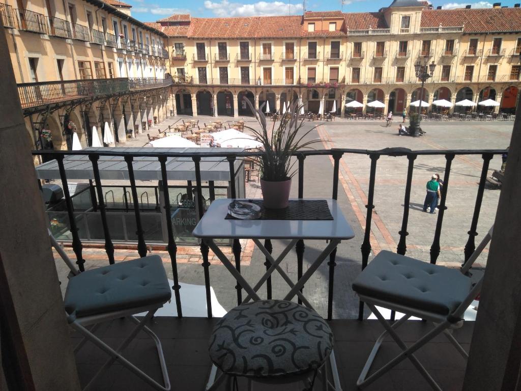 a balcony with a table and chairs on a city street at Viva León in León
