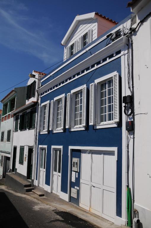 um edifício azul com portas e janelas brancas em Casa BuonVento em Horta