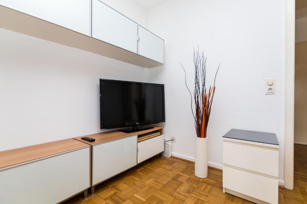 a living room with a flat screen tv on a white wall at Altstadt Kurzestr in Düsseldorf