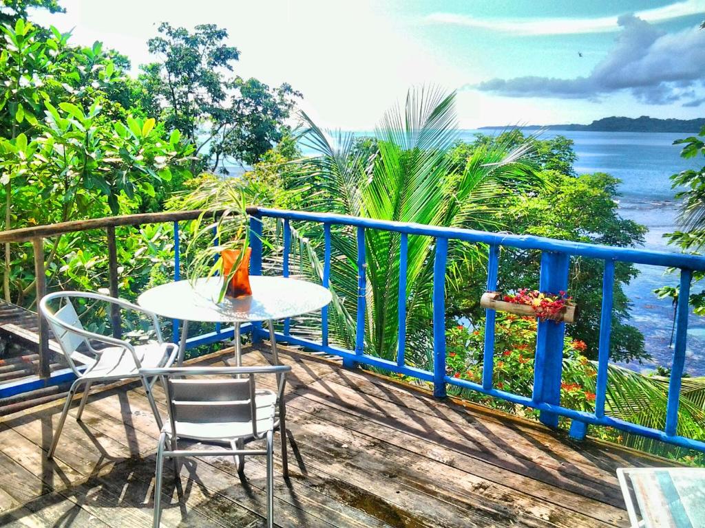 a table and chairs on a balcony with a view of the ocean at Mosana Reef Garden B&B in Bocas del Toro