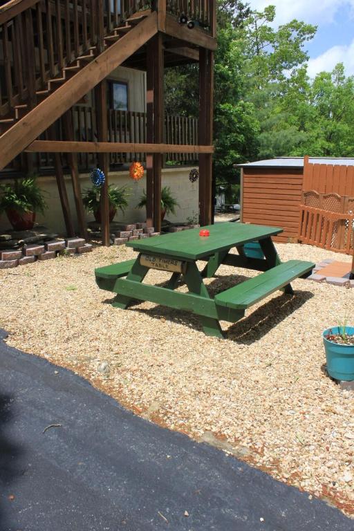 un tavolo da picnic verde di fronte a una casa di Shady Acre Inn and Suites a Branson West