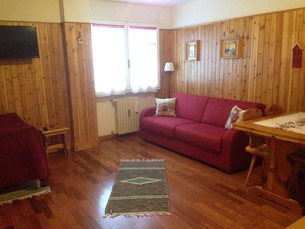 sala de estar con sofá rojo y mesa en Mountain Charming Studio en Madesimo