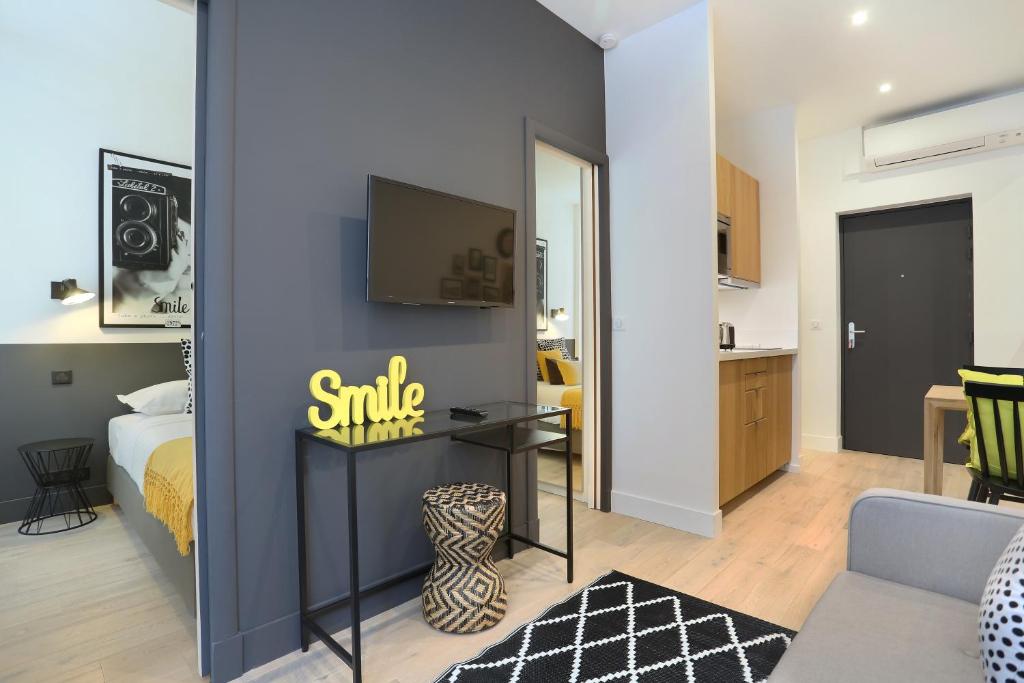 a bedroom with a bed and a tv on a wall at Rent a Room - Residence Blanche in Paris