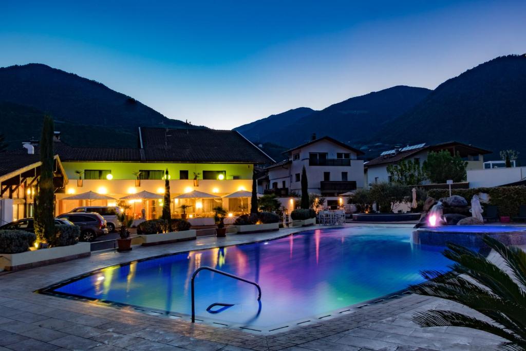 a swimming pool in a resort at night at Schlosshof Charme Resort – Hotel & Camping in Lana