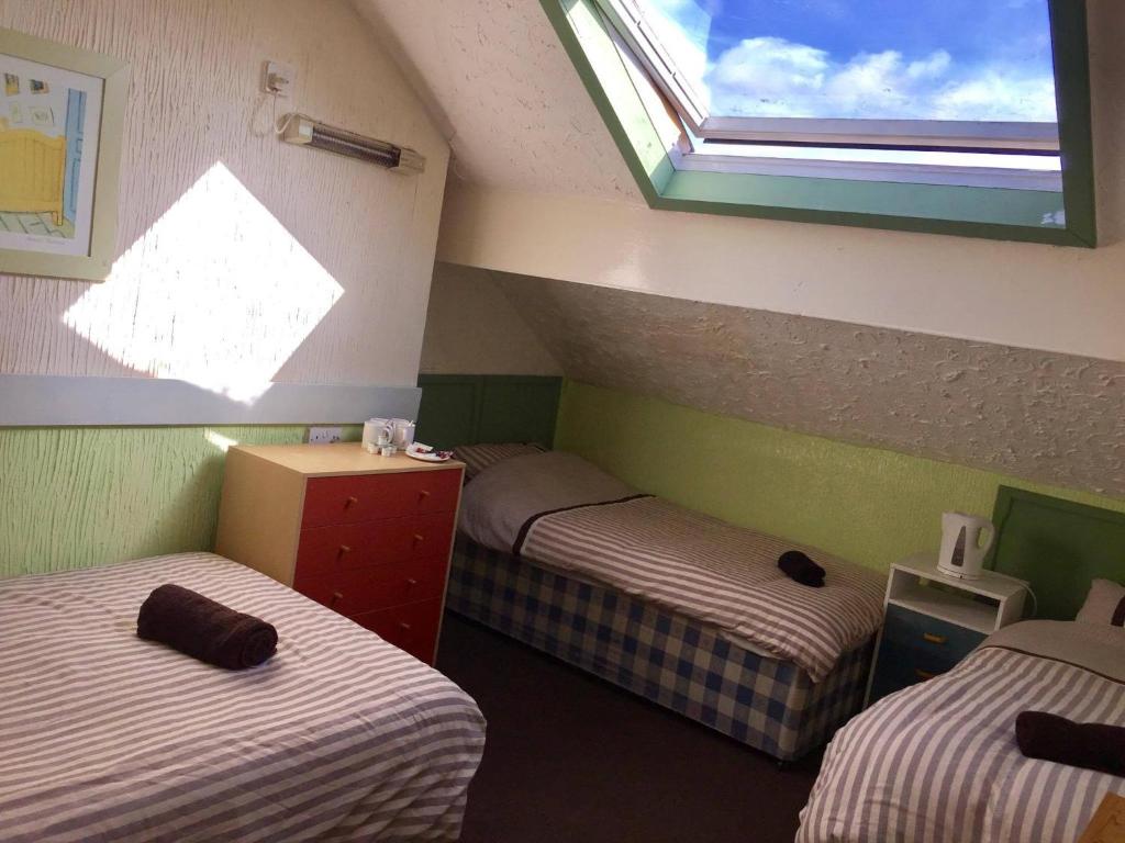 een kamer met 2 aparte bedden en een raam bij The Galloway in Blackpool