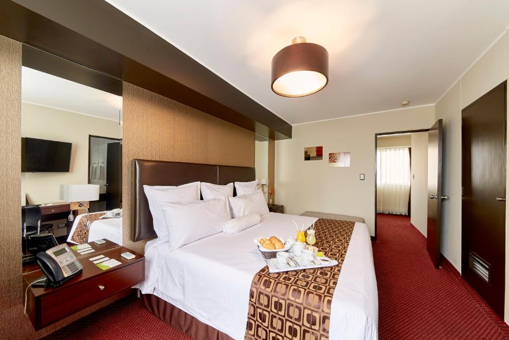una habitación de hotel con una cama grande y un teléfono en Hotel Carrera, en Lima