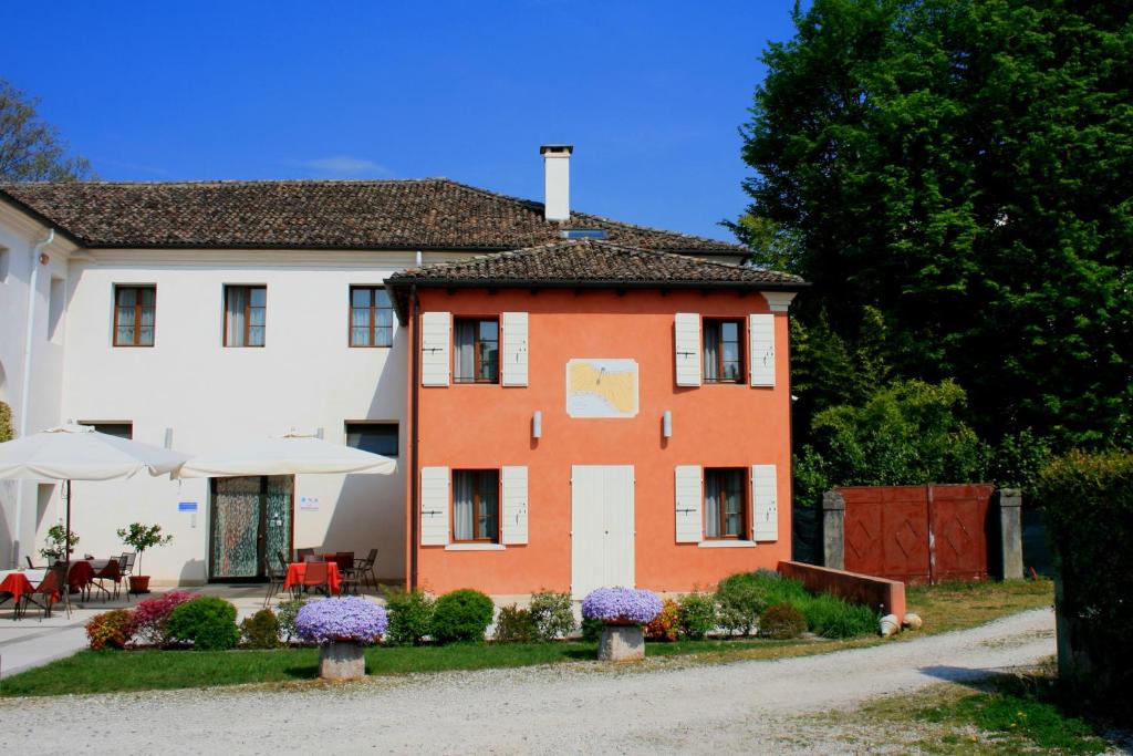 a house with a yard with purple flowers in front of it at La Meridiana in Crocetta del Montello