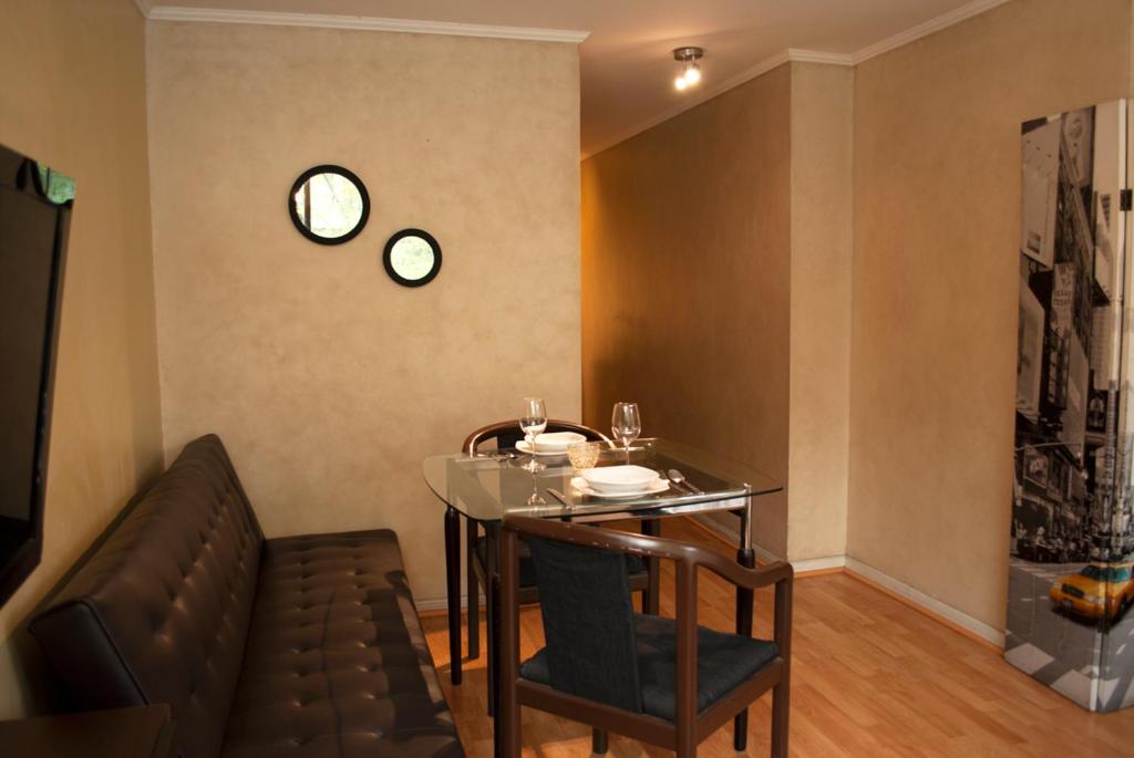 comedor con mesa de cristal y silla en Amg Apartments San Sebastian, en Santiago