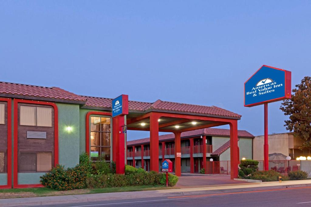 un edificio de hotel con un cartel delante en America's Best Value Inn & Suites Bakersfield Central, en Bakersfield