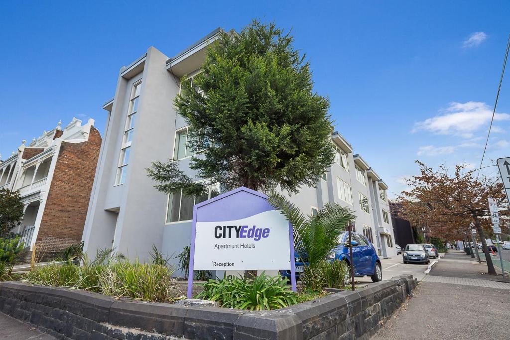 una señal de la cresta de la ciudad frente a un edificio en City Edge East Melbourne Apartment Hotel, en Melbourne