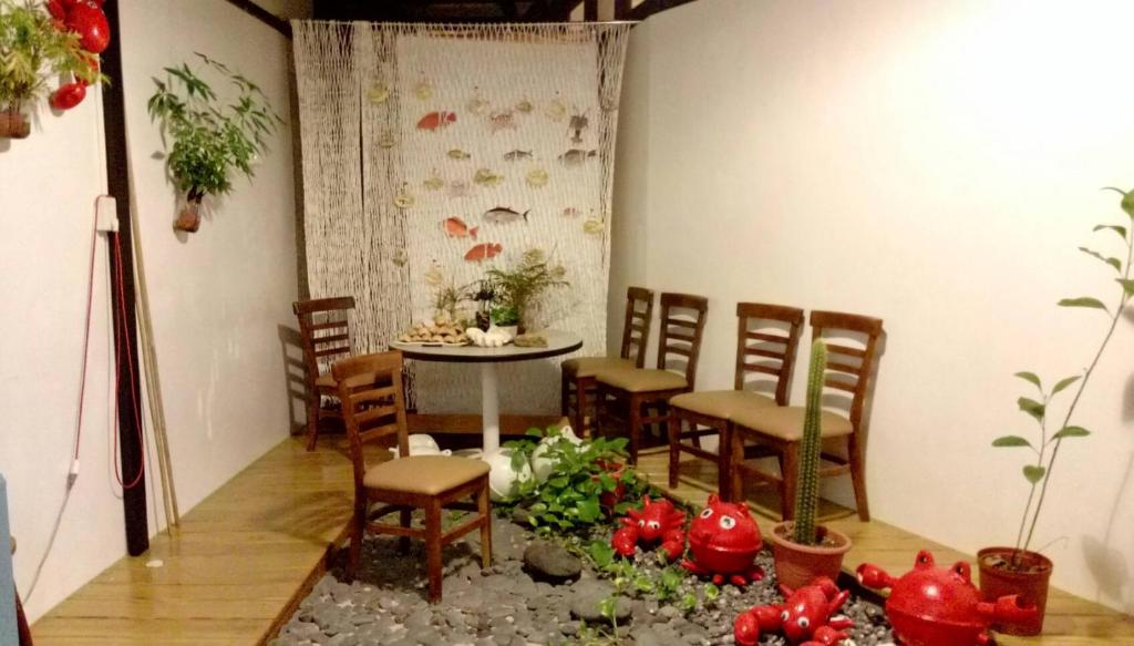 a room with a table and chairs and plants at Red octopus in Magong