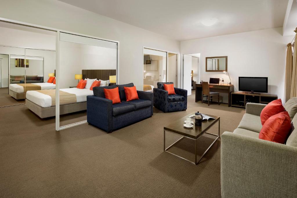 a living room with a couch and a bed and a room at Quest Mildura in Mildura