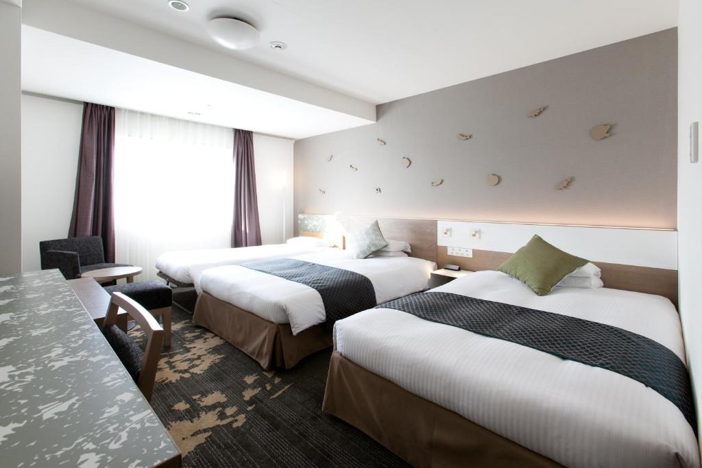 Postel nebo postele na pokoji v ubytování Toyama Excel Hotel Tokyu